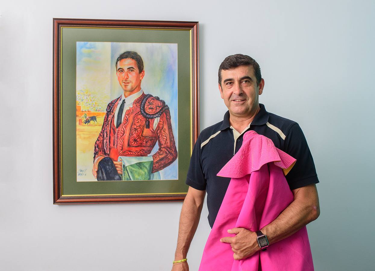Mario Alcón, junto a su retrato vestido de luces. Fue novillero y banderillero.