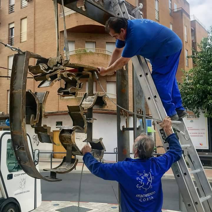 Operarios colocando el escudo
