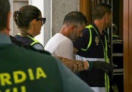 El detenido, junto a dos agentes de policía judicial de la Policía Nacional, en el acceso al juzgado.