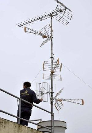 Un operario modifica una antena de televisión. 