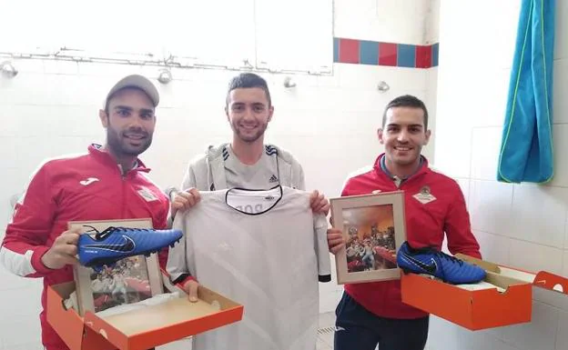 Michel García, Manu Roldán y Juan Alberto Barrero (de iada. a drcha.) mostrando regalos que le hicieron sus chavales cadetes.