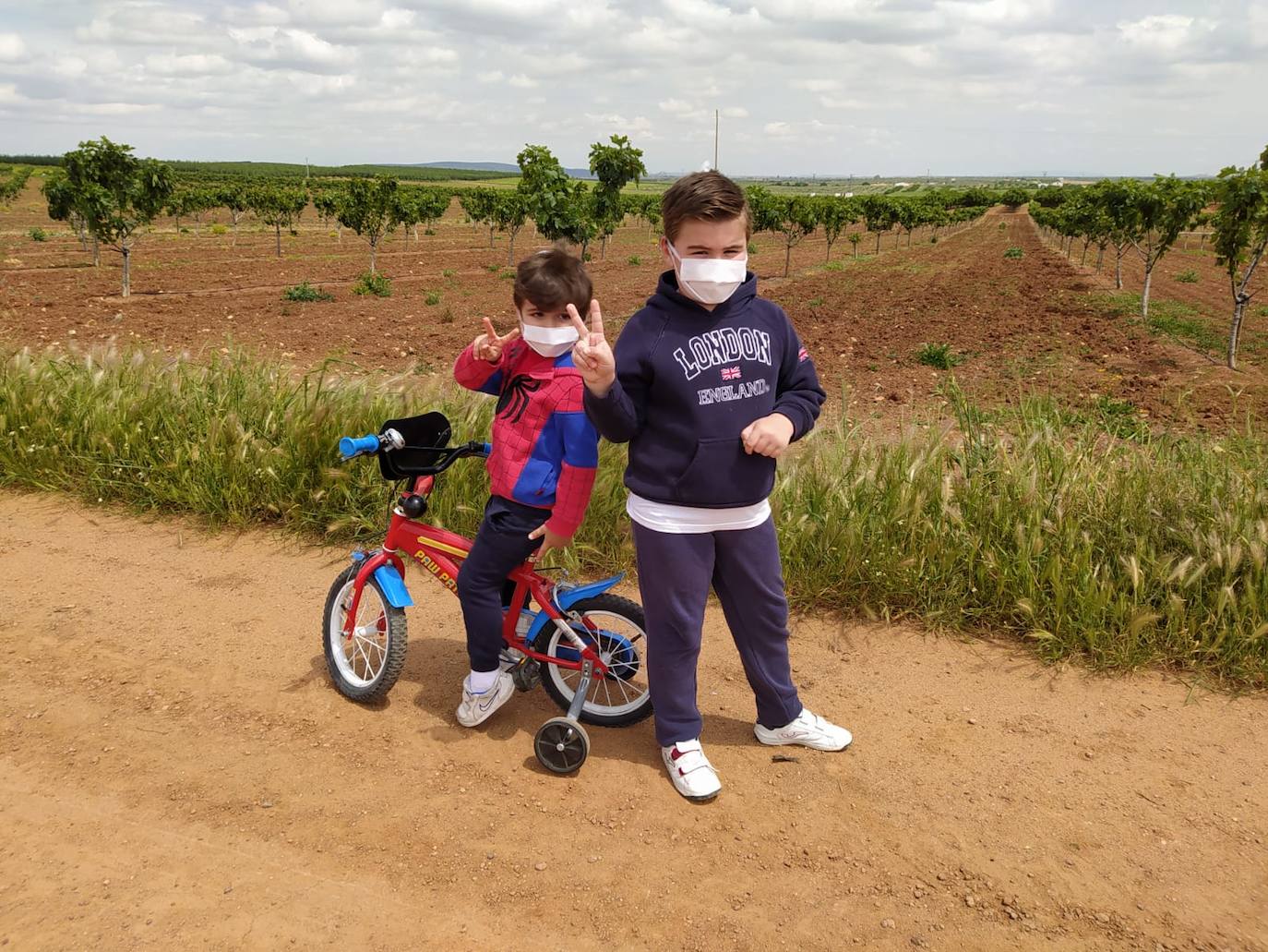 Miguel (i) y Pablo saludan a su mamá en su paseo después de 43 días encerrados en su casa.