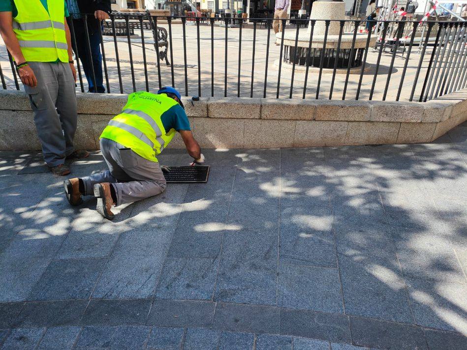 Un operario colocando la placa en la Plaza de España.