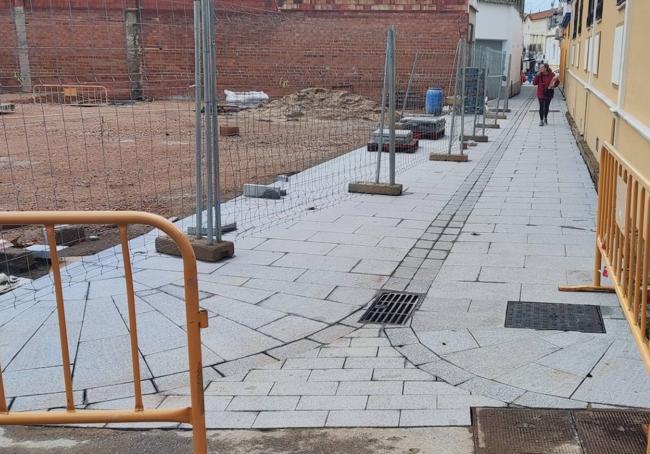 Una mujer cruzando la calleja Angosta desde San Gregorio hasta Estacada y comprobando el piso.