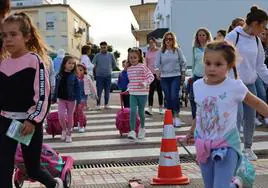 Niños, niñas y familiares de camino hacia el colegio