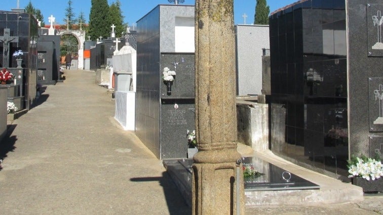 Cruz de piedra,detrás de la cual está la tumba en la que será inhumado el sacerdote.