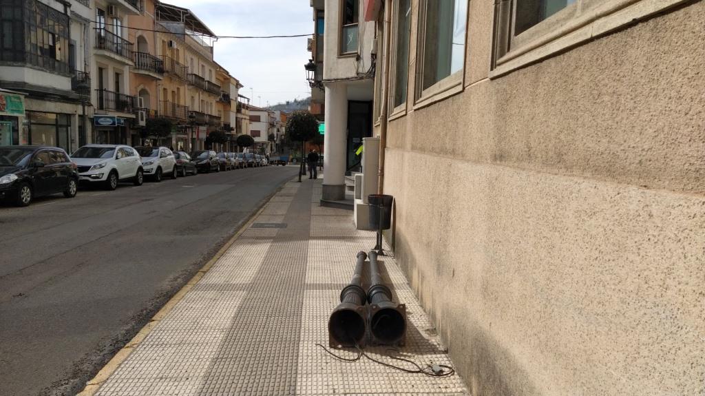 Farolas retiradas en la travesía de la EX-203, depositadas en la acera. 