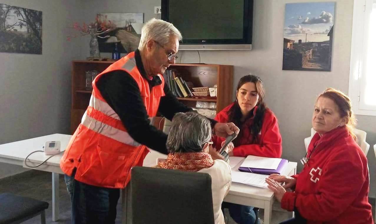 Gregorio Jiménez tomando la tensión a una persona mayor, acompañado de Vanessa y Tani.