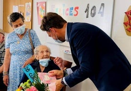 Aurelia, junto a su madre, durante la entrega del ramo de flores por parte del alcalde.