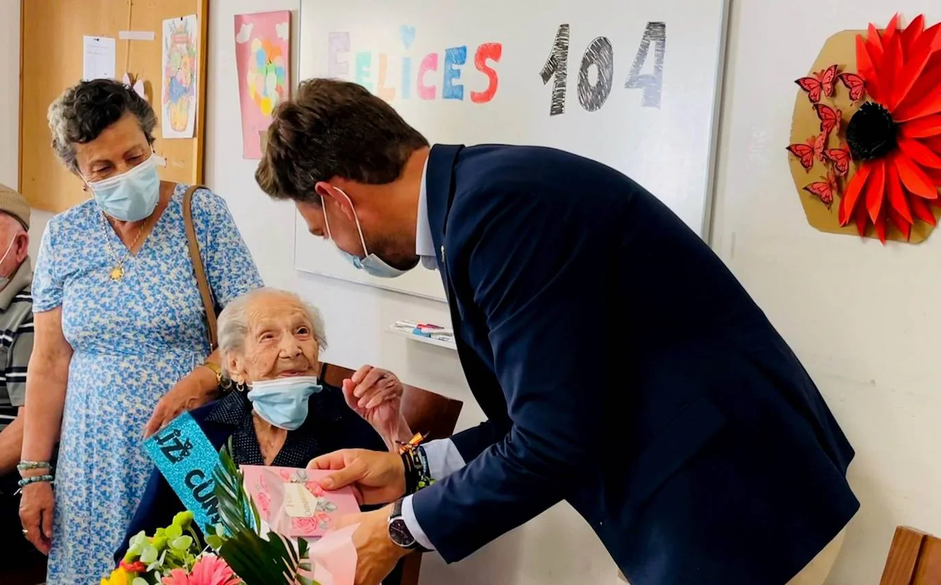 Aurelia, junto a su madre, durante la entrega del ramo de flores por parte del alcalde.