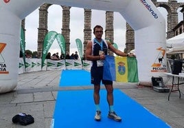 Miguel Ángel junto al acueducto romano de Segovia exhibiendo la bandera de Jaraíz de la Vera.