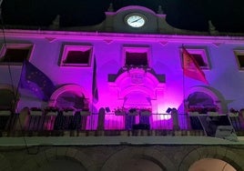 Fachada principal de la Casa Consistorial jaraiceña iluminada del color morado.