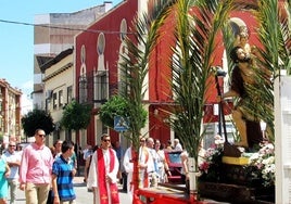 Procesión con la imagen transportada en un vehículo.