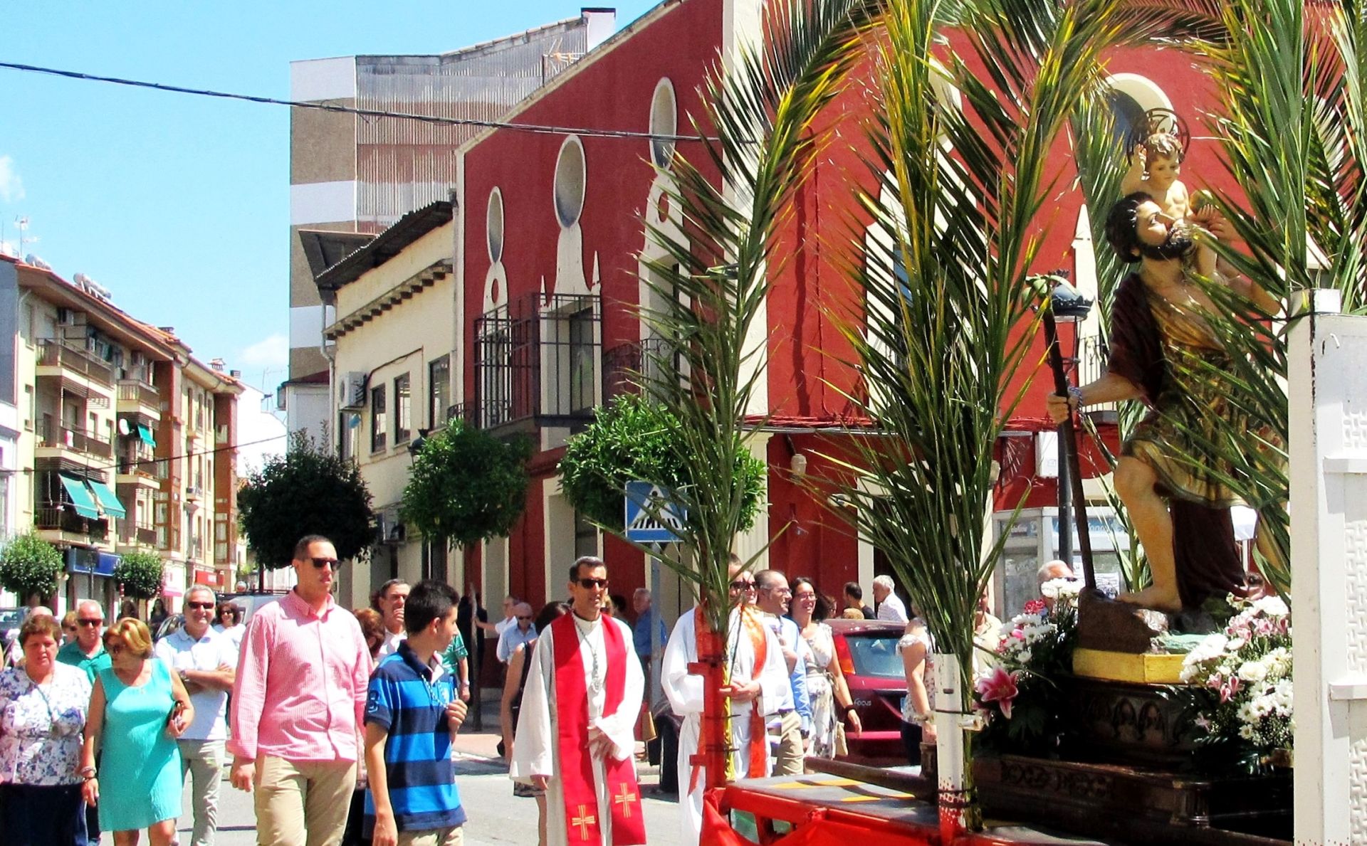 Procesión con la imagen transportada en un vehículo.