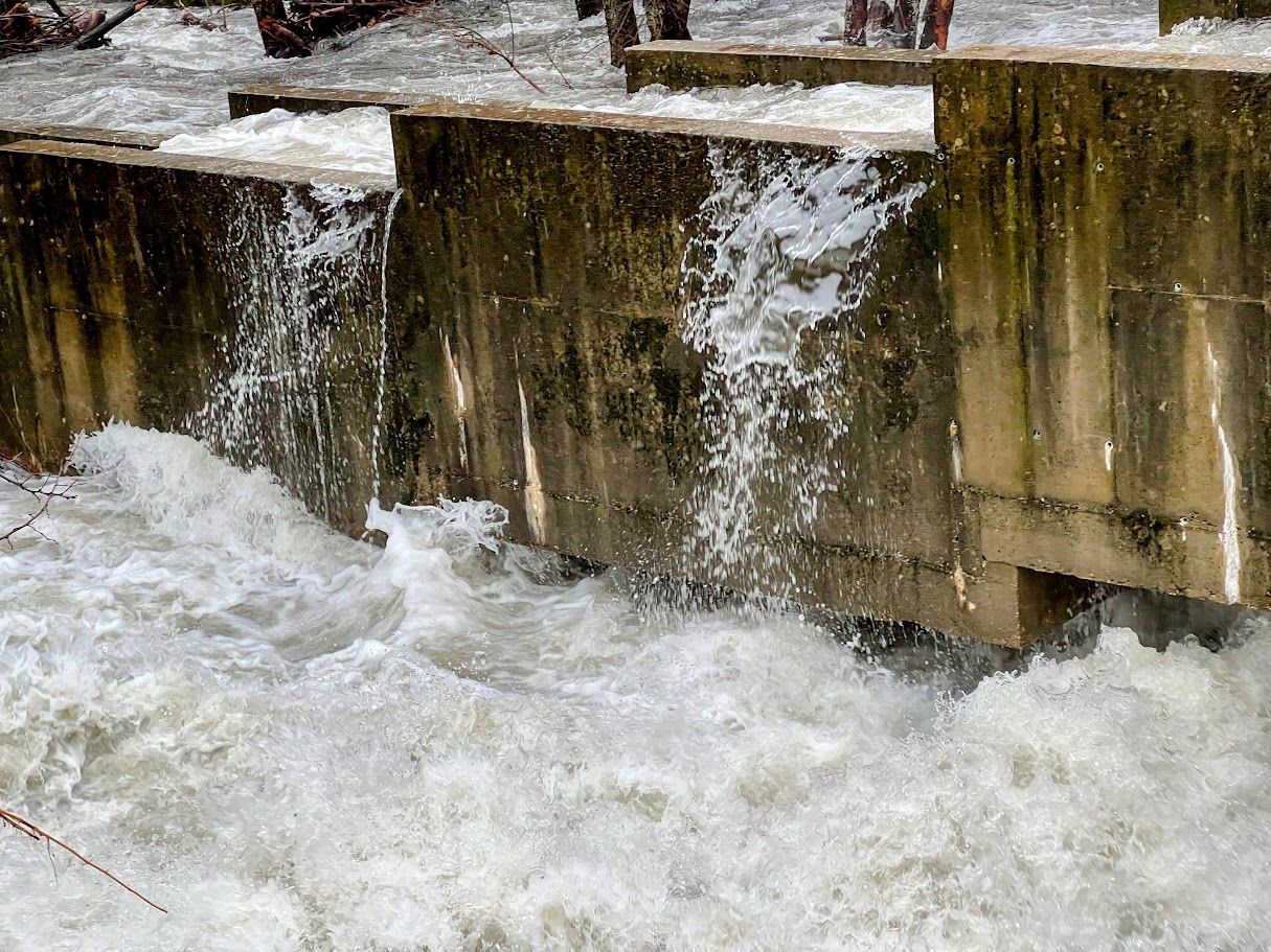 La escala de la presa expulsando a gua a borbotones.