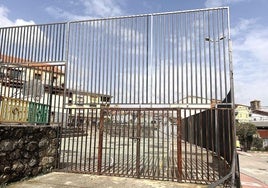 Vallado y puerta de acceso a la pista polideportiva urbana.
