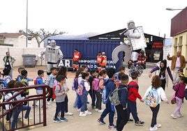 Alumnos de Primaria entrando en el pabellón de deportes saludados por robots.