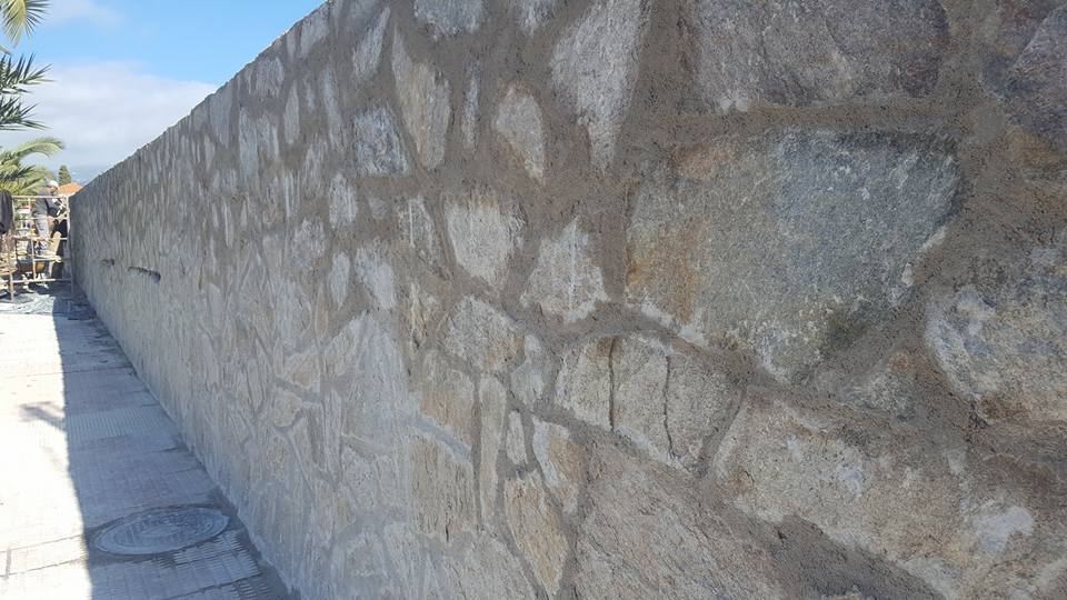 EL muro lateral, antes encalado es ahora de forrado de piedra.