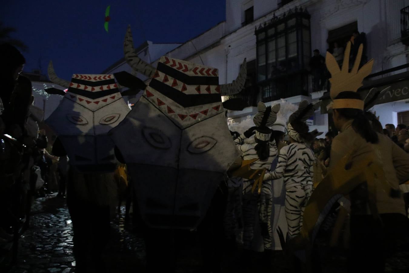 Jerez de los Caballeros se inundó de magia, ilusión y colorido con su tradicional Cabalgata de Reyes Magos. Primero, fueron los mayores de la Residencia Hernando de Soto quienes disfrutaron de la presencia de sus Majestades de Oriente junto a la visita de autoridades y miembros de las distintas cofradías y hermandades. Desde el Ayuntamiento se había dispuesto este año un recorrido distinto y el el entorno del citado centro, junto al parque de Santa Lucía, fue el punto de partida de una cabalgata que vivió uno de sus momentos más extraordinarios en la Plaza de España con mucha presencia de público. Junto a los tronos de Melchor, Gaspar y Baltasar, carrozas realizadas por el Ayuntamiento, destacó la participación de asociaciones y colectivos: vecinos de La Bazana, 'Euexia Rural', la Asociación cultural del Belén Santa Ángela y la Asociación juvenil 'La Trouppe', que con más de 100 componentes ofreció un gran espectáculo con la recreación de la fantasía de 'El Rey león'. La música acrecentó el ambiente de ilusión, con los sones de la Agrupación Musical 'Nuestro Padre Jesús Nazareno' y la Agrupación Musical 'Maestro Sousa' de la OJE. Los más pequeños vivieron la cita con emoción y fueron los verdaderos protagonistas del mejor prólogo de una de las noches más especiales del año.Además del amplio despliegue de fantasía y colorido, estuvo la labor de: Policía Local, Cruz Roja, Protección Civil, Bomberos, Guardia Civil, para el buen desarrollo de este evento.