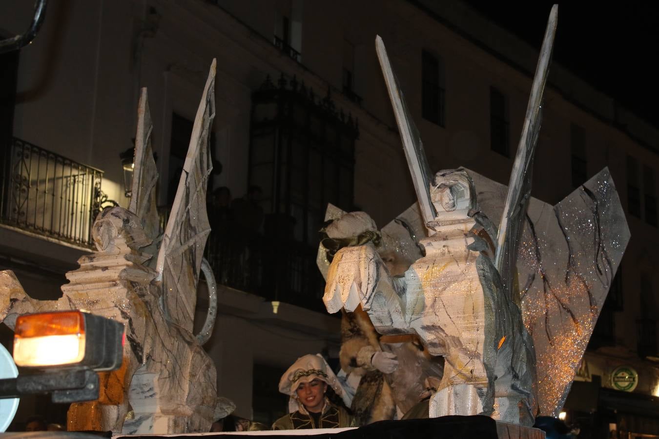 Jerez de los Caballeros se inundó de magia, ilusión y colorido con su tradicional Cabalgata de Reyes Magos. Primero, fueron los mayores de la Residencia Hernando de Soto quienes disfrutaron de la presencia de sus Majestades de Oriente junto a la visita de autoridades y miembros de las distintas cofradías y hermandades. Desde el Ayuntamiento se había dispuesto este año un recorrido distinto y el el entorno del citado centro, junto al parque de Santa Lucía, fue el punto de partida de una cabalgata que vivió uno de sus momentos más extraordinarios en la Plaza de España con mucha presencia de público. Junto a los tronos de Melchor, Gaspar y Baltasar, carrozas realizadas por el Ayuntamiento, destacó la participación de asociaciones y colectivos: vecinos de La Bazana, 'Euexia Rural', la Asociación cultural del Belén Santa Ángela y la Asociación juvenil 'La Trouppe', que con más de 100 componentes ofreció un gran espectáculo con la recreación de la fantasía de 'El Rey león'. La música acrecentó el ambiente de ilusión, con los sones de la Agrupación Musical 'Nuestro Padre Jesús Nazareno' y la Agrupación Musical 'Maestro Sousa' de la OJE. Los más pequeños vivieron la cita con emoción y fueron los verdaderos protagonistas del mejor prólogo de una de las noches más especiales del año.Además del amplio despliegue de fantasía y colorido, estuvo la labor de: Policía Local, Cruz Roja, Protección Civil, Bomberos, Guardia Civil, para el buen desarrollo de este evento.