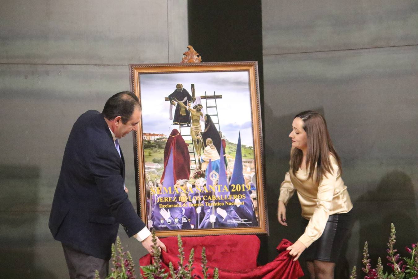 El auditorio del Conventual San Agustín acogió, ayer, la presentación del cartel anunciador de la Semana Santa 2019 de Jerez de los Caballeros. Un cartel, obra del jerezano Juan Manuel Pérez Vázquez, que se consagra, un año más, como mosaico de tradición, sentimiento y fervor de un pueblo por su Semana Mayor y que, esta vez, tiene como protagonista el momento en el que Jesús es bajado de la Cruz, talla de la Cofradía de Nuestro Padre Jesús Nazareno, obra de León Ortega.