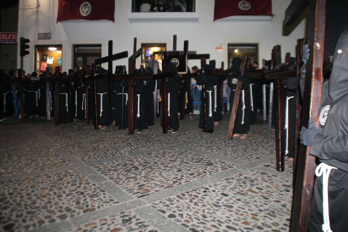 Cientos de personas se concentraro la noche de este Lunes Santo a cada tramo del recorrido del Viacruucis que realiza la Hermandad de Penitentes del Santísimo Cristo de la Vera Cruz, para acompanar en silencio el rosario de cruces que describe esta procesión singular en la que aparecen integrados, como expresión máxima de la penitencia, los empalaos.La ciudad de las torres, la ciudad templaria, volvió a ofrecer el marco perfecto para esta vivencia íntima que custodia tantas razones. Su contemplación fue especial en calles plenas de tipismo, de fachadas blancas sobre las que destacaban las pequeñas cruces de madera, señalando el itinerario. Rincones plenos de encanto, encrucijadas que abrigaron el sacrificio y la oración de los varios cientos de penitentes y mujeres con velas encendidas que participaron en esta estación de penitencia con el Santísimo Cristo de la Vera Cruz como referente. Su espera en el entorno de la iglesia de San Miguel, con tantas cruces enmarcando la escena, marco el momento culmen.