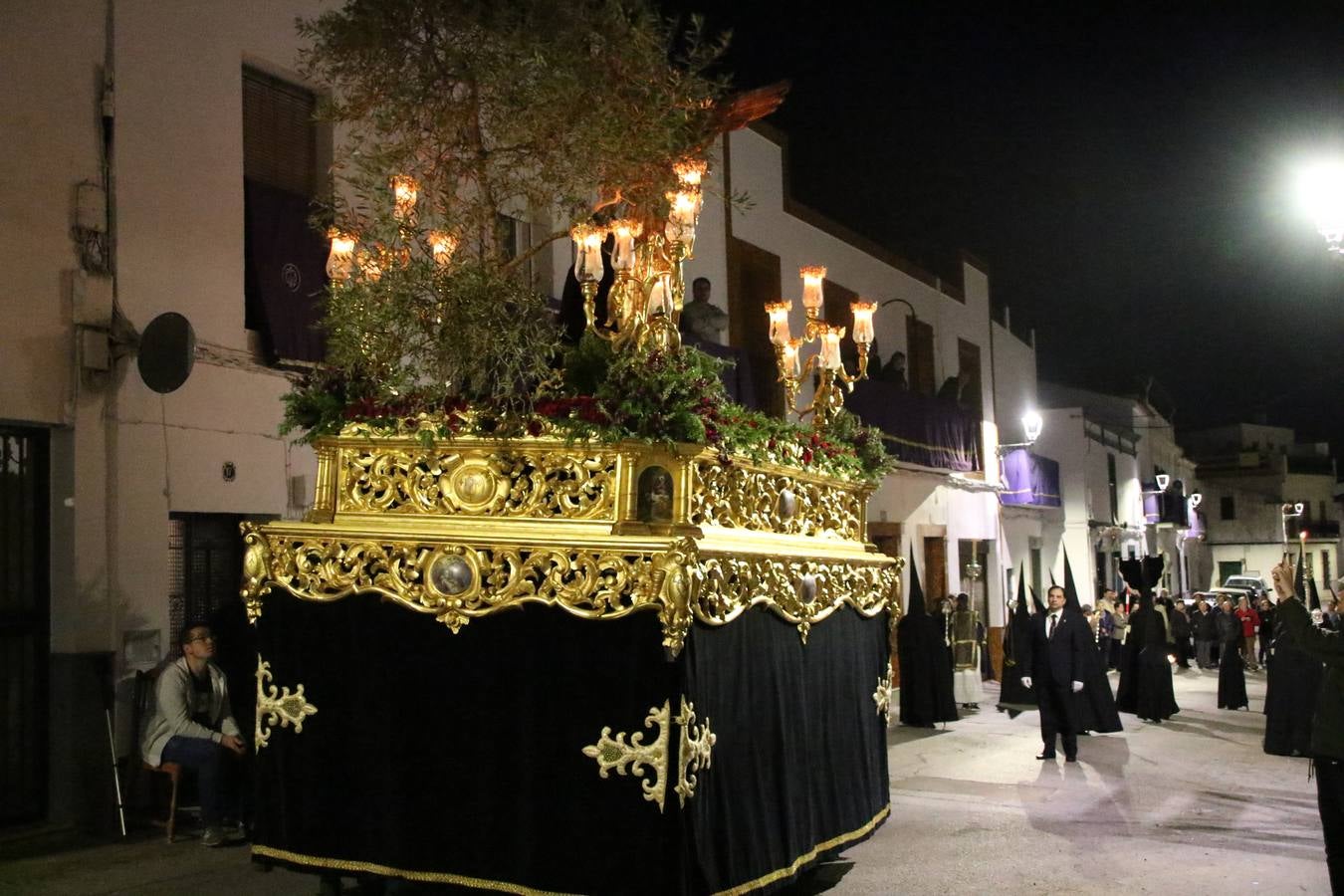 Siguiendo la tradición y al aviso de tres toques, la puerta del Perdón de la Iglesia de San Miguel Arcángel se abrió, ayer, para que la Antigua y Pontificia Cofradía de Nuestra Señora del Rosario y Jesús Orando en el Huerto realizase su desfile procesional. Un Martes Santo más en el que el silencio, el recogimiento y la austeridad recalan en las calles de Jerez de los Caballeros ante las imágenes de 'Jesús orando en el Huerto' y 'Nuestra Señora del Silencio'. Un silencio roto por la voz de los capataces, el andar de los costaleros, las marchas de la Asociación Musical del municipio y, este año, de manera especial, por la voz del tenor extremeño Juan Ledesma. Ledesma cantó a la Virgen del Silencio ante el Arco de Burgos, con el acompañamiento de la citada Asociación Musical.