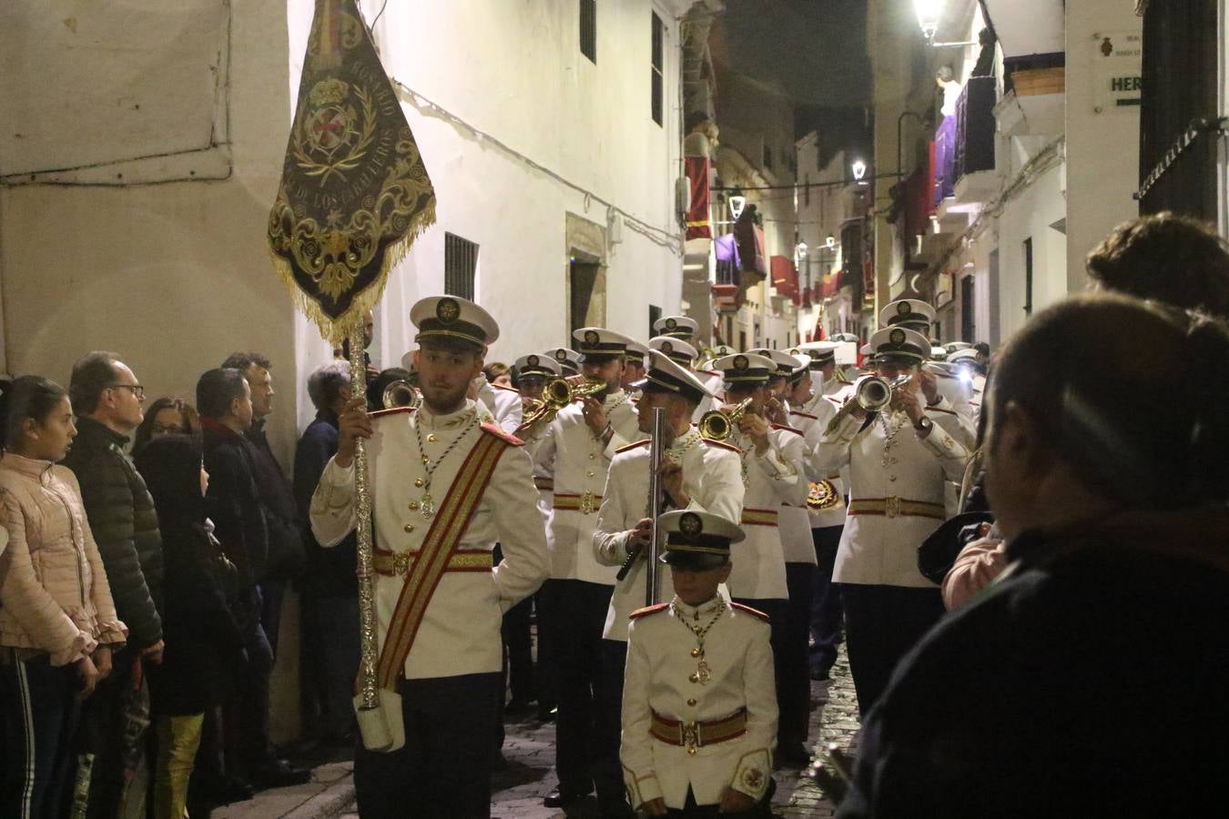 La vista al cielo se convertía, ayer, en una de las prácticas más repetida por los jerezanos. La lluvia amenazaba con marcar un antes y después en la Semana Santa jerezana 2019, Fiesta de Interés Turístico Nacional, e impedir la salida de la Cofradía del Señor 'Ecce-Homo', protagonista del Miércoles Santo. Una leve llovizna que, comenzaría a principio de la tarde, se convirtió en persistente a medida que pasaban las horas. Razón por la que la Cofradía decidió retrasar su hora de salida hasta pasadas las 21:30 horas, cuando la puerta del Perdón de San Miguel Arcángel se abría para iniciar el desfile procesional. Un desfile procesional que se vio interrumpido, de nuevo, por la lluvia, obligando al Señor 'Ecce-Homo' y Nuestra Señora de los Desamparados a regresar al templo. 