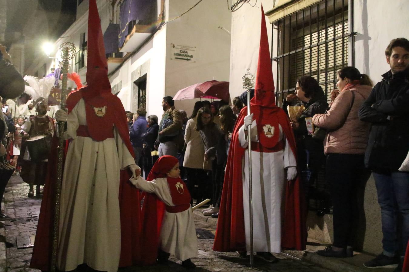 La vista al cielo se convertía, ayer, en una de las prácticas más repetida por los jerezanos. La lluvia amenazaba con marcar un antes y después en la Semana Santa jerezana 2019, Fiesta de Interés Turístico Nacional, e impedir la salida de la Cofradía del Señor 'Ecce-Homo', protagonista del Miércoles Santo. Una leve llovizna que, comenzaría a principio de la tarde, se convirtió en persistente a medida que pasaban las horas. Razón por la que la Cofradía decidió retrasar su hora de salida hasta pasadas las 21:30 horas, cuando la puerta del Perdón de San Miguel Arcángel se abría para iniciar el desfile procesional. Un desfile procesional que se vio interrumpido, de nuevo, por la lluvia, obligando al Señor 'Ecce-Homo' y Nuestra Señora de los Desamparados a regresar al templo. 