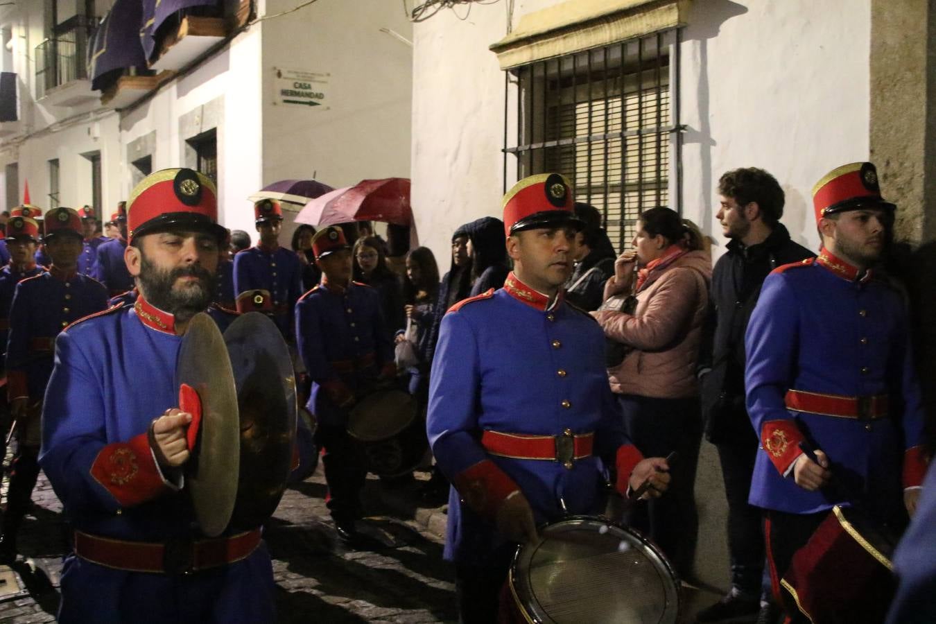 La vista al cielo se convertía, ayer, en una de las prácticas más repetida por los jerezanos. La lluvia amenazaba con marcar un antes y después en la Semana Santa jerezana 2019, Fiesta de Interés Turístico Nacional, e impedir la salida de la Cofradía del Señor 'Ecce-Homo', protagonista del Miércoles Santo. Una leve llovizna que, comenzaría a principio de la tarde, se convirtió en persistente a medida que pasaban las horas. Razón por la que la Cofradía decidió retrasar su hora de salida hasta pasadas las 21:30 horas, cuando la puerta del Perdón de San Miguel Arcángel se abría para iniciar el desfile procesional. Un desfile procesional que se vio interrumpido, de nuevo, por la lluvia, obligando al Señor 'Ecce-Homo' y Nuestra Señora de los Desamparados a regresar al templo. 
