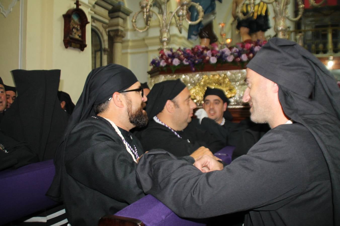 Las emociones llenaron también anoche la ermita de Los Santos Mártires, donde se quedaron guardados todos los afanes, las ilusiones y la devoción que no pudieron tener reflejo en la procesión de las colas largas, La Cofradía del Señor Coronado de Espinas decidió no salir ante la adversidad de la climatología y en el interior de este pequeño templo se vivieron momentos de gran emotividad.La Guardia Civil de Jerez de los Caballeros rindió honores a s Madrina, María Santísima de la Amargura. Los sones de las bandas y agrupaciones que iban a participar en el desfile procesional expandieron su eco desde el Llano de los Mártires para acompañar a los costaleros de cada uno de los tres Pasos, que fueron mecidos a su compás. El jovencísimo saetero Julián Jaramillo, de tan solo 12 años y natural de Segura de León, hizo vibrar a los presentes con su saeta al Coronado.Y entre las oraciones del párroco, Antonio María Rejano y los sacerdotes que le acompañaron, asomaron también las lágrimas.El momento más emotivo se vivió con el sentido homenaje a Manuel Labrador González, Manolo 'Cornelio' a quien Marisa Sánchez, en nombre de la junta de gobierno de la Cofradía del Señor Coronado, dedicó palabras llenas de afecto y reconocimiento, destacando su condición de «trabajador sin igual», su carácter innovador, su generosidad, sus consejos a jóvenes y mayores en el seno de esta Cofradía de la que dijo, «es piedra angular» y su extraordinaria labor. Manuel recibió un libro y una precioso cartel realizada por José Tomás Pérez Indiano, a semejanza del que hace tres años anunció la Semana Santa Jerezana. Emocionado, Manuel agradeció el cariño y dedicó este homenaje a su familia y a todas las madres.