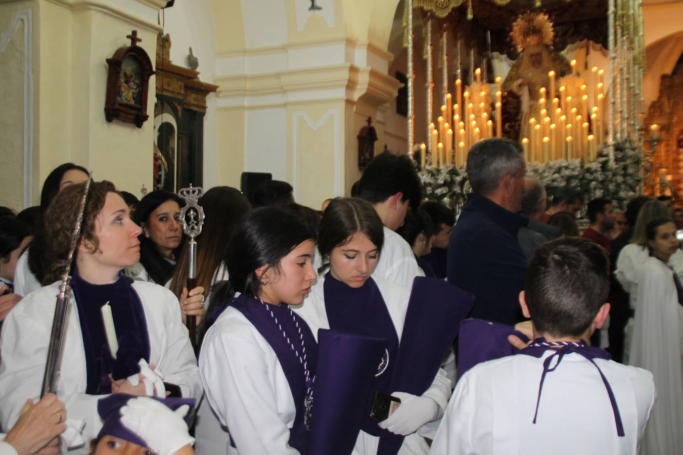 Las emociones llenaron también anoche la ermita de Los Santos Mártires, donde se quedaron guardados todos los afanes, las ilusiones y la devoción que no pudieron tener reflejo en la procesión de las colas largas, La Cofradía del Señor Coronado de Espinas decidió no salir ante la adversidad de la climatología y en el interior de este pequeño templo se vivieron momentos de gran emotividad.La Guardia Civil de Jerez de los Caballeros rindió honores a s Madrina, María Santísima de la Amargura. Los sones de las bandas y agrupaciones que iban a participar en el desfile procesional expandieron su eco desde el Llano de los Mártires para acompañar a los costaleros de cada uno de los tres Pasos, que fueron mecidos a su compás. El jovencísimo saetero Julián Jaramillo, de tan solo 12 años y natural de Segura de León, hizo vibrar a los presentes con su saeta al Coronado.Y entre las oraciones del párroco, Antonio María Rejano y los sacerdotes que le acompañaron, asomaron también las lágrimas.El momento más emotivo se vivió con el sentido homenaje a Manuel Labrador González, Manolo 'Cornelio' a quien Marisa Sánchez, en nombre de la junta de gobierno de la Cofradía del Señor Coronado, dedicó palabras llenas de afecto y reconocimiento, destacando su condición de «trabajador sin igual», su carácter innovador, su generosidad, sus consejos a jóvenes y mayores en el seno de esta Cofradía de la que dijo, «es piedra angular» y su extraordinaria labor. Manuel recibió un libro y una precioso cartel realizada por José Tomás Pérez Indiano, a semejanza del que hace tres años anunció la Semana Santa Jerezana. Emocionado, Manuel agradeció el cariño y dedicó este homenaje a su familia y a todas las madres.
