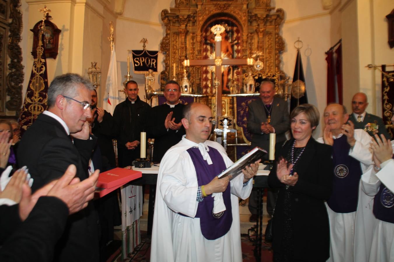 Las emociones llenaron también anoche la ermita de Los Santos Mártires, donde se quedaron guardados todos los afanes, las ilusiones y la devoción que no pudieron tener reflejo en la procesión de las colas largas, La Cofradía del Señor Coronado de Espinas decidió no salir ante la adversidad de la climatología y en el interior de este pequeño templo se vivieron momentos de gran emotividad.La Guardia Civil de Jerez de los Caballeros rindió honores a s Madrina, María Santísima de la Amargura. Los sones de las bandas y agrupaciones que iban a participar en el desfile procesional expandieron su eco desde el Llano de los Mártires para acompañar a los costaleros de cada uno de los tres Pasos, que fueron mecidos a su compás. El jovencísimo saetero Julián Jaramillo, de tan solo 12 años y natural de Segura de León, hizo vibrar a los presentes con su saeta al Coronado.Y entre las oraciones del párroco, Antonio María Rejano y los sacerdotes que le acompañaron, asomaron también las lágrimas.El momento más emotivo se vivió con el sentido homenaje a Manuel Labrador González, Manolo 'Cornelio' a quien Marisa Sánchez, en nombre de la junta de gobierno de la Cofradía del Señor Coronado, dedicó palabras llenas de afecto y reconocimiento, destacando su condición de «trabajador sin igual», su carácter innovador, su generosidad, sus consejos a jóvenes y mayores en el seno de esta Cofradía de la que dijo, «es piedra angular» y su extraordinaria labor. Manuel recibió un libro y una precioso cartel realizada por José Tomás Pérez Indiano, a semejanza del que hace tres años anunció la Semana Santa Jerezana. Emocionado, Manuel agradeció el cariño y dedicó este homenaje a su familia y a todas las madres.
