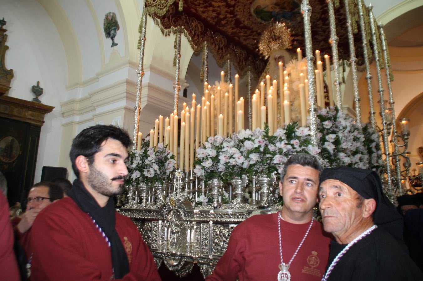 Las emociones llenaron también anoche la ermita de Los Santos Mártires, donde se quedaron guardados todos los afanes, las ilusiones y la devoción que no pudieron tener reflejo en la procesión de las colas largas, La Cofradía del Señor Coronado de Espinas decidió no salir ante la adversidad de la climatología y en el interior de este pequeño templo se vivieron momentos de gran emotividad.La Guardia Civil de Jerez de los Caballeros rindió honores a s Madrina, María Santísima de la Amargura. Los sones de las bandas y agrupaciones que iban a participar en el desfile procesional expandieron su eco desde el Llano de los Mártires para acompañar a los costaleros de cada uno de los tres Pasos, que fueron mecidos a su compás. El jovencísimo saetero Julián Jaramillo, de tan solo 12 años y natural de Segura de León, hizo vibrar a los presentes con su saeta al Coronado.Y entre las oraciones del párroco, Antonio María Rejano y los sacerdotes que le acompañaron, asomaron también las lágrimas.El momento más emotivo se vivió con el sentido homenaje a Manuel Labrador González, Manolo 'Cornelio' a quien Marisa Sánchez, en nombre de la junta de gobierno de la Cofradía del Señor Coronado, dedicó palabras llenas de afecto y reconocimiento, destacando su condición de «trabajador sin igual», su carácter innovador, su generosidad, sus consejos a jóvenes y mayores en el seno de esta Cofradía de la que dijo, «es piedra angular» y su extraordinaria labor. Manuel recibió un libro y una precioso cartel realizada por José Tomás Pérez Indiano, a semejanza del que hace tres años anunció la Semana Santa Jerezana. Emocionado, Manuel agradeció el cariño y dedicó este homenaje a su familia y a todas las madres.