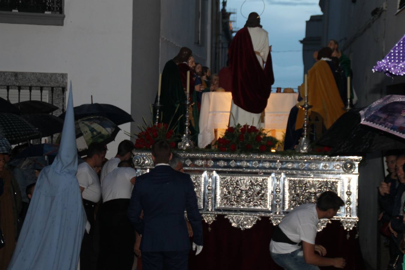 La lluvia que durante las primeras horas de la tarde se contuvo, hizo acto de presencia nada más asomarse a la calle la procesión de las túnicas celestes, que organiza la Archicofrafía del Santísimo Sacramento. Todas las emociones se vieron frustradas y el templo de San Bartolomé fue refugio para el sentimiento de quienes anhelaban acompañar esta estación de penitencia en la que se representa el momento de la institución de la Santa Cena, que junto al de Jesús ante Pilatos, fueron los únicos que realizaron su salida de la iglesia patronal. El Cristo de la Piedad, imagen impresionante en el itinerario de la Semana Santa jerezana, y la hermosa Virgen de la Paza, se quedaron dentro.Los sones de las Agruaciones y bandas que iban a acompañar este desfile sonaron especiales para bailar estas dos imágenes y servir de consuelo, mientras brotaban lágrimas en los ojos de algunos niños que encuentran en esta Cofradía su bautismo nazareno. La oración también acompañó estos momentos de tristeza al tiempo tan especiales.