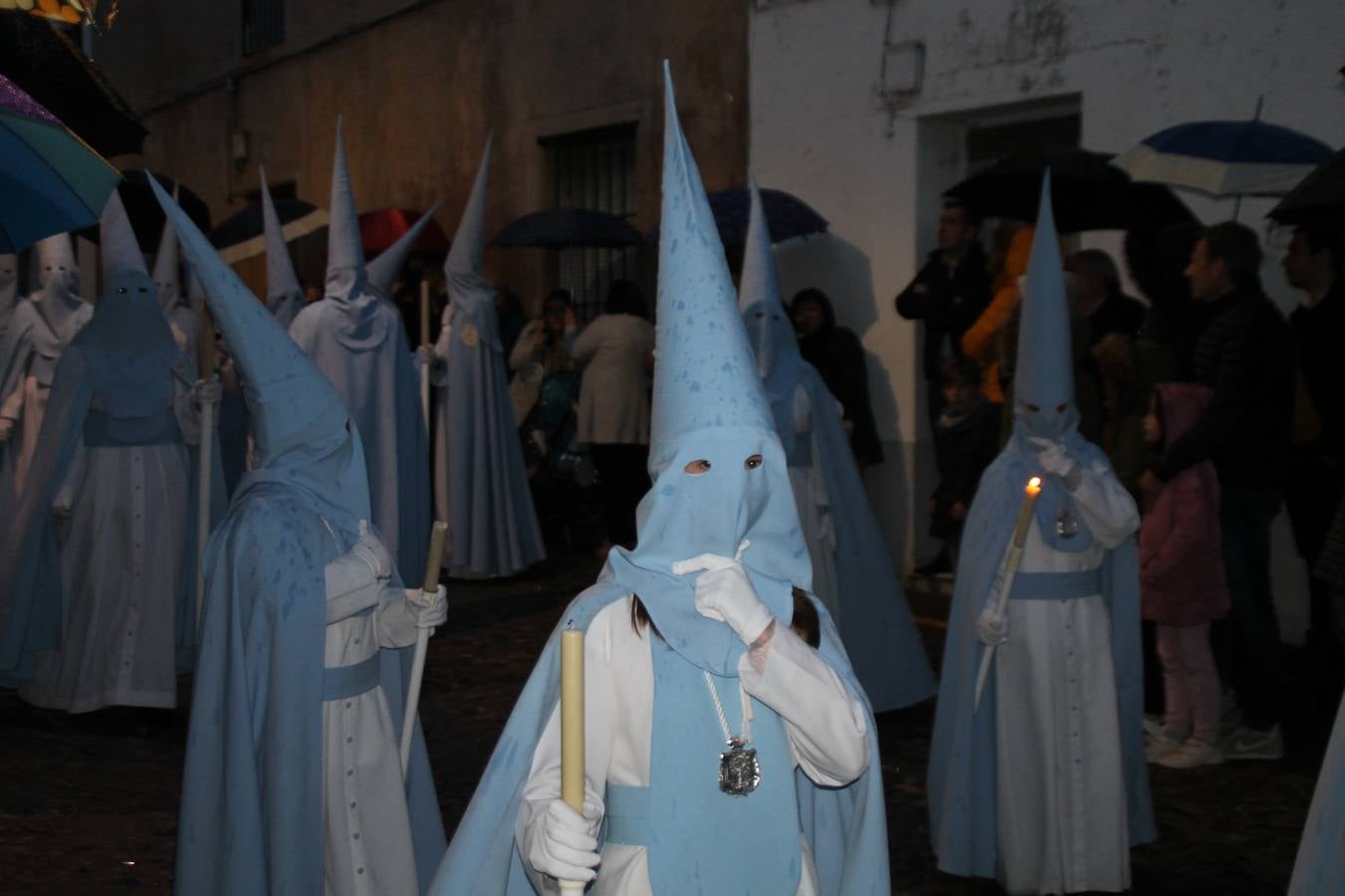 La lluvia que durante las primeras horas de la tarde se contuvo, hizo acto de presencia nada más asomarse a la calle la procesión de las túnicas celestes, que organiza la Archicofrafía del Santísimo Sacramento. Todas las emociones se vieron frustradas y el templo de San Bartolomé fue refugio para el sentimiento de quienes anhelaban acompañar esta estación de penitencia en la que se representa el momento de la institución de la Santa Cena, que junto al de Jesús ante Pilatos, fueron los únicos que realizaron su salida de la iglesia patronal. El Cristo de la Piedad, imagen impresionante en el itinerario de la Semana Santa jerezana, y la hermosa Virgen de la Paza, se quedaron dentro.Los sones de las Agruaciones y bandas que iban a acompañar este desfile sonaron especiales para bailar estas dos imágenes y servir de consuelo, mientras brotaban lágrimas en los ojos de algunos niños que encuentran en esta Cofradía su bautismo nazareno. La oración también acompañó estos momentos de tristeza al tiempo tan especiales.