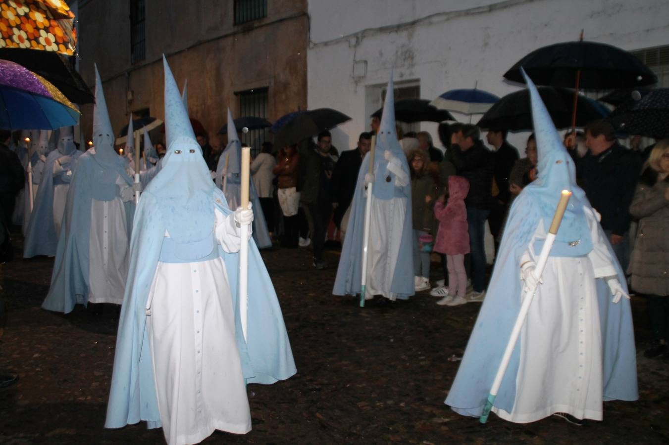 La lluvia que durante las primeras horas de la tarde se contuvo, hizo acto de presencia nada más asomarse a la calle la procesión de las túnicas celestes, que organiza la Archicofrafía del Santísimo Sacramento. Todas las emociones se vieron frustradas y el templo de San Bartolomé fue refugio para el sentimiento de quienes anhelaban acompañar esta estación de penitencia en la que se representa el momento de la institución de la Santa Cena, que junto al de Jesús ante Pilatos, fueron los únicos que realizaron su salida de la iglesia patronal. El Cristo de la Piedad, imagen impresionante en el itinerario de la Semana Santa jerezana, y la hermosa Virgen de la Paza, se quedaron dentro.Los sones de las Agruaciones y bandas que iban a acompañar este desfile sonaron especiales para bailar estas dos imágenes y servir de consuelo, mientras brotaban lágrimas en los ojos de algunos niños que encuentran en esta Cofradía su bautismo nazareno. La oración también acompañó estos momentos de tristeza al tiempo tan especiales.