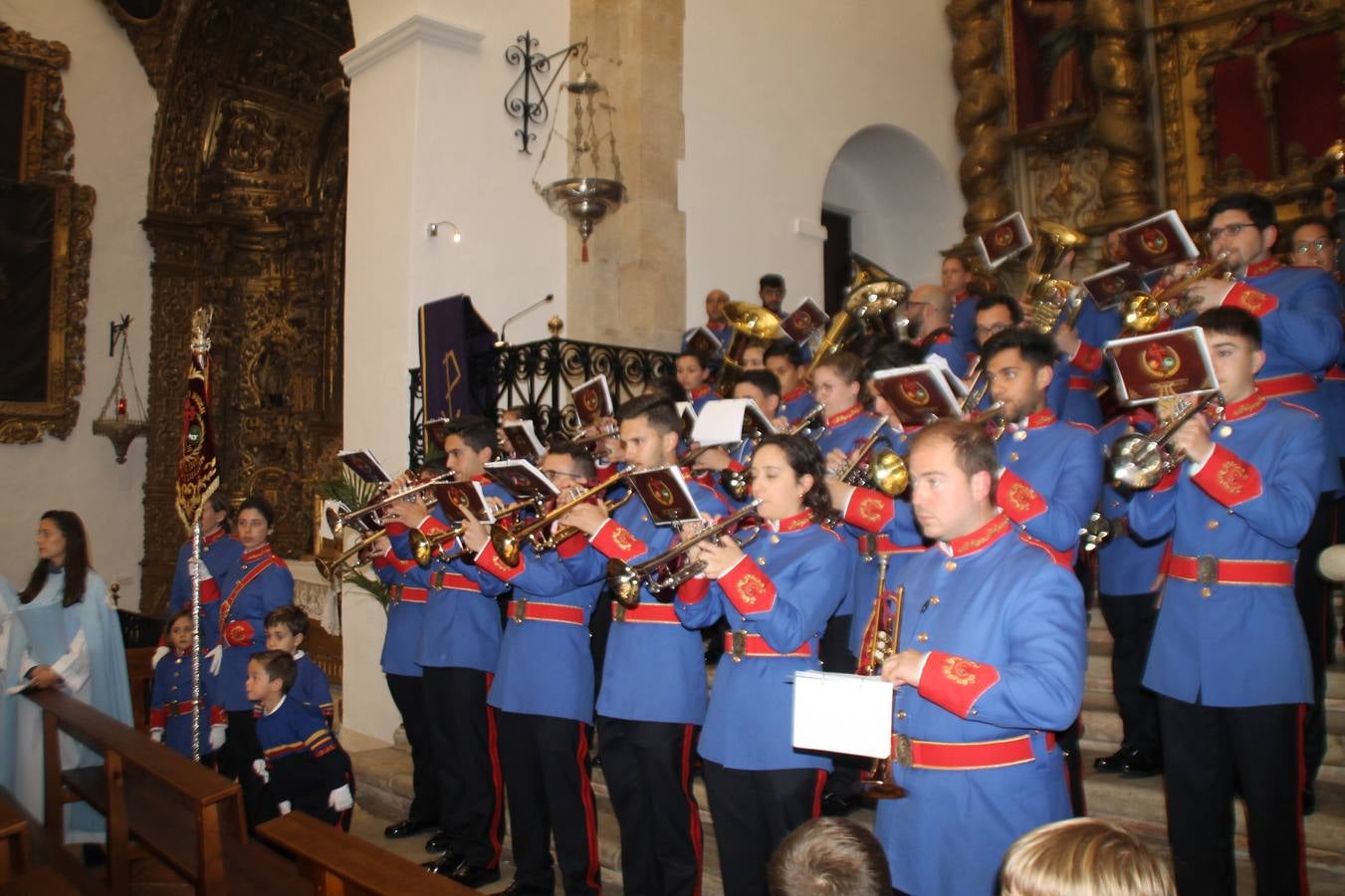 La lluvia que durante las primeras horas de la tarde se contuvo, hizo acto de presencia nada más asomarse a la calle la procesión de las túnicas celestes, que organiza la Archicofrafía del Santísimo Sacramento. Todas las emociones se vieron frustradas y el templo de San Bartolomé fue refugio para el sentimiento de quienes anhelaban acompañar esta estación de penitencia en la que se representa el momento de la institución de la Santa Cena, que junto al de Jesús ante Pilatos, fueron los únicos que realizaron su salida de la iglesia patronal. El Cristo de la Piedad, imagen impresionante en el itinerario de la Semana Santa jerezana, y la hermosa Virgen de la Paza, se quedaron dentro.Los sones de las Agruaciones y bandas que iban a acompañar este desfile sonaron especiales para bailar estas dos imágenes y servir de consuelo, mientras brotaban lágrimas en los ojos de algunos niños que encuentran en esta Cofradía su bautismo nazareno. La oración también acompañó estos momentos de tristeza al tiempo tan especiales.