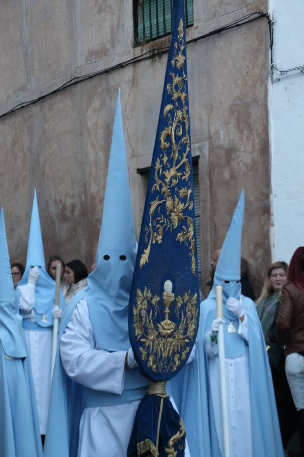La lluvia que durante las primeras horas de la tarde se contuvo, hizo acto de presencia nada más asomarse a la calle la procesión de las túnicas celestes, que organiza la Archicofrafía del Santísimo Sacramento. Todas las emociones se vieron frustradas y el templo de San Bartolomé fue refugio para el sentimiento de quienes anhelaban acompañar esta estación de penitencia en la que se representa el momento de la institución de la Santa Cena, que junto al de Jesús ante Pilatos, fueron los únicos que realizaron su salida de la iglesia patronal. El Cristo de la Piedad, imagen impresionante en el itinerario de la Semana Santa jerezana, y la hermosa Virgen de la Paza, se quedaron dentro.Los sones de las Agruaciones y bandas que iban a acompañar este desfile sonaron especiales para bailar estas dos imágenes y servir de consuelo, mientras brotaban lágrimas en los ojos de algunos niños que encuentran en esta Cofradía su bautismo nazareno. La oración también acompañó estos momentos de tristeza al tiempo tan especiales.