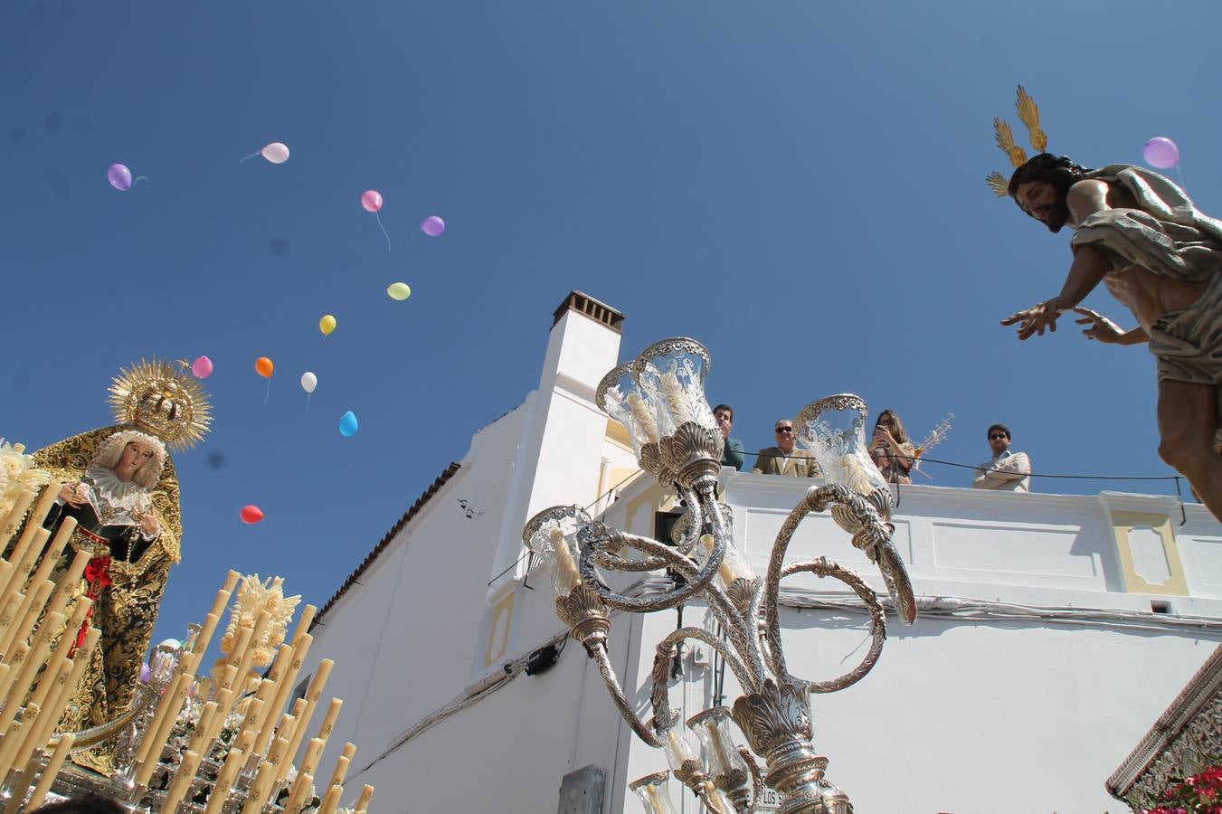 La luz y el gozo han puesto un gran broche a una Semana Santa, aciaga en sus momentos más intensos, a causa del mal tiempo que desde la noche del Miércoles y hasta el Viernes Santo trastocó en buena medida su desarrollo.Hoy el sol ha lucido en el cielo que como, cada Domingo de Resurrección, ha servido de Palio al hermoso Paso de la Virgen del Rosario, haciendo resplandecer, al tiempo, el momento culmen de esta celebración, el reencuentro en la Madre y el Hijo en la Fuente de los Santos, abarrotada de público. El momento ha sido emocionante, con los costaleros de la virgen y del Paso del Resucitado subiendo los brazos al cielo para representar el abrazo de ambas imágenes, ante la tradicional suelta de globos de ecolores y el estrépito de cornetas y tambores.La procesión ha seguido su curso hacia la Plaza de España, también muy concurrida, siendo en este escenario donde, miembros de Grupo Joven de la Cofradía del Coronado han regalado una petalada a la Virgen del Rosario. Ha sido un ofecimiento de la citada Cofradía que la noche del pasado Jueves no pudo obsequiar a su Virgen de la Amargura con esta lluvia de pétalos de rosas, a causa del mal tiempo.Así ha terminado la Semana Santa, incompleta para varias cofradías. La parte más amarga la han vivido la Cofradía del Señor Ecce-Homo que vió acortado su recorrido el Miércoles en una noche desapacible. También la Archicofradía del Santísimo Sacramento que apenas pudo asomarse a la calle y vió concentradas sus emociones en el templo patronal y la Cofradía del Señor Coronado de Espinas que también concentró el sentimieno y la devoción en la ermita de los Santos Mártires, viviendo momenos íntimos de gran emotividad. La Hermandad de la Esperanza Macarena brilló, sin embargo, en la Madrugá jerezana y la Cofradía de Nuestro Padre Jesús Nazareno derrochó fervor la tarde del Viernes en el interior de la iglesia visigoda de Santa María.