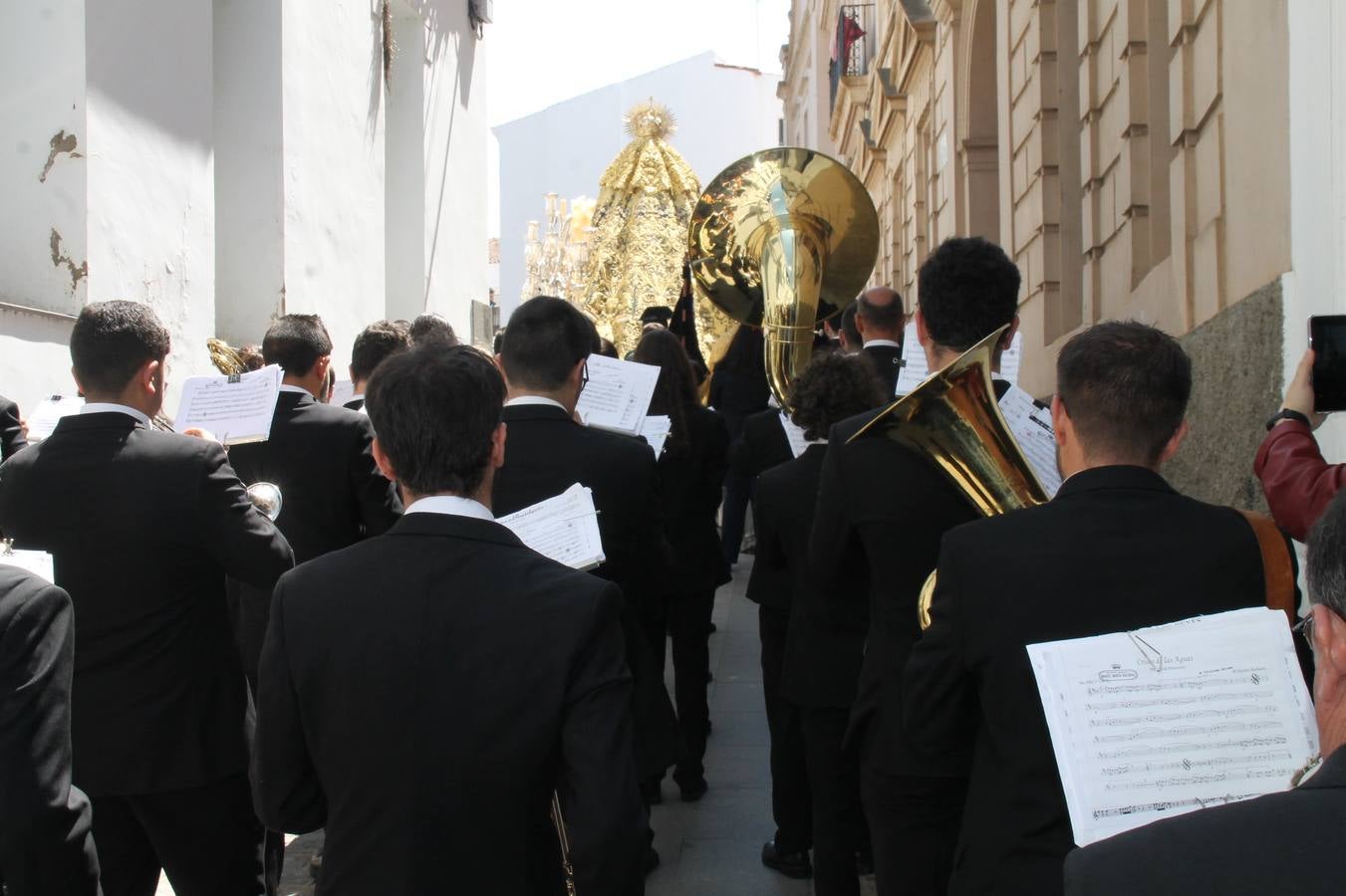La luz y el gozo han puesto un gran broche a una Semana Santa, aciaga en sus momentos más intensos, a causa del mal tiempo que desde la noche del Miércoles y hasta el Viernes Santo trastocó en buena medida su desarrollo.Hoy el sol ha lucido en el cielo que como, cada Domingo de Resurrección, ha servido de Palio al hermoso Paso de la Virgen del Rosario, haciendo resplandecer, al tiempo, el momento culmen de esta celebración, el reencuentro en la Madre y el Hijo en la Fuente de los Santos, abarrotada de público. El momento ha sido emocionante, con los costaleros de la virgen y del Paso del Resucitado subiendo los brazos al cielo para representar el abrazo de ambas imágenes, ante la tradicional suelta de globos de ecolores y el estrépito de cornetas y tambores.La procesión ha seguido su curso hacia la Plaza de España, también muy concurrida, siendo en este escenario donde, miembros de Grupo Joven de la Cofradía del Coronado han regalado una petalada a la Virgen del Rosario. Ha sido un ofecimiento de la citada Cofradía que la noche del pasado Jueves no pudo obsequiar a su Virgen de la Amargura con esta lluvia de pétalos de rosas, a causa del mal tiempo.Así ha terminado la Semana Santa, incompleta para varias cofradías. La parte más amarga la han vivido la Cofradía del Señor Ecce-Homo que vió acortado su recorrido el Miércoles en una noche desapacible. También la Archicofradía del Santísimo Sacramento que apenas pudo asomarse a la calle y vió concentradas sus emociones en el templo patronal y la Cofradía del Señor Coronado de Espinas que también concentró el sentimieno y la devoción en la ermita de los Santos Mártires, viviendo momenos íntimos de gran emotividad. La Hermandad de la Esperanza Macarena brilló, sin embargo, en la Madrugá jerezana y la Cofradía de Nuestro Padre Jesús Nazareno derrochó fervor la tarde del Viernes en el interior de la iglesia visigoda de Santa María.