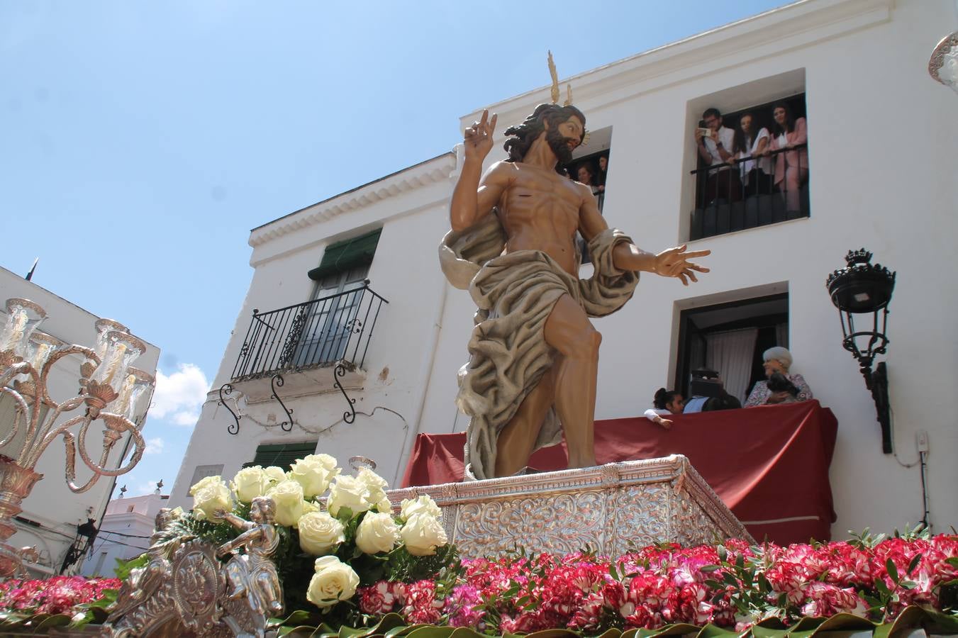 La luz y el gozo han puesto un gran broche a una Semana Santa, aciaga en sus momentos más intensos, a causa del mal tiempo que desde la noche del Miércoles y hasta el Viernes Santo trastocó en buena medida su desarrollo.Hoy el sol ha lucido en el cielo que como, cada Domingo de Resurrección, ha servido de Palio al hermoso Paso de la Virgen del Rosario, haciendo resplandecer, al tiempo, el momento culmen de esta celebración, el reencuentro en la Madre y el Hijo en la Fuente de los Santos, abarrotada de público. El momento ha sido emocionante, con los costaleros de la virgen y del Paso del Resucitado subiendo los brazos al cielo para representar el abrazo de ambas imágenes, ante la tradicional suelta de globos de ecolores y el estrépito de cornetas y tambores.La procesión ha seguido su curso hacia la Plaza de España, también muy concurrida, siendo en este escenario donde, miembros de Grupo Joven de la Cofradía del Coronado han regalado una petalada a la Virgen del Rosario. Ha sido un ofecimiento de la citada Cofradía que la noche del pasado Jueves no pudo obsequiar a su Virgen de la Amargura con esta lluvia de pétalos de rosas, a causa del mal tiempo.Así ha terminado la Semana Santa, incompleta para varias cofradías. La parte más amarga la han vivido la Cofradía del Señor Ecce-Homo que vió acortado su recorrido el Miércoles en una noche desapacible. También la Archicofradía del Santísimo Sacramento que apenas pudo asomarse a la calle y vió concentradas sus emociones en el templo patronal y la Cofradía del Señor Coronado de Espinas que también concentró el sentimieno y la devoción en la ermita de los Santos Mártires, viviendo momenos íntimos de gran emotividad. La Hermandad de la Esperanza Macarena brilló, sin embargo, en la Madrugá jerezana y la Cofradía de Nuestro Padre Jesús Nazareno derrochó fervor la tarde del Viernes en el interior de la iglesia visigoda de Santa María.