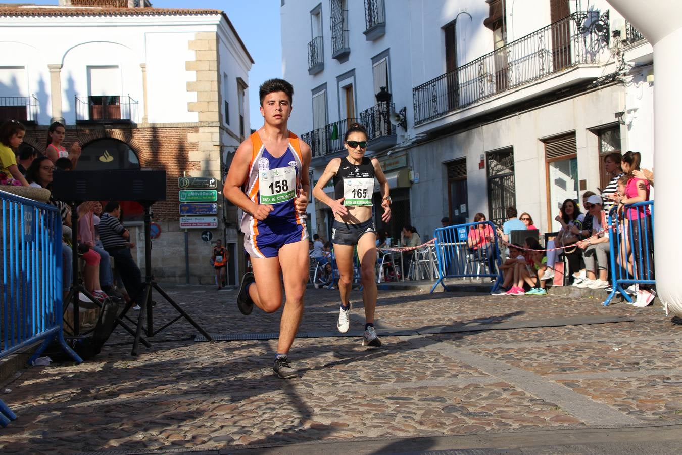 La Plaza de España de Jerez de los Caballeros acogió, ayer, la XXI Carrera Popular y VIII Caminata por la Salud y Solidaridad, organizada por la Concejalía de Juventud y Deportes del Ayuntamiento de Jerez con el apoyo del Programa de Dinamización Deportiva de la Mancomunidad Sierra Suroeste. Esta edición congregó a más de 250 participantes entre todas las categorías y se recaudaron 84 kilos de alimentos y 75 euros destinados a Cruz Roja en Jerez. La citada prueba se consagra, año tras año, como una de las citas deportivas ineludibles y más esperadas por los jerezanos y jerezanas. 