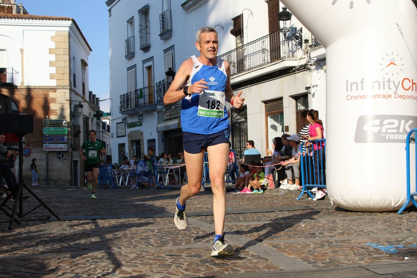 La Plaza de España de Jerez de los Caballeros acogió, ayer, la XXI Carrera Popular y VIII Caminata por la Salud y Solidaridad, organizada por la Concejalía de Juventud y Deportes del Ayuntamiento de Jerez con el apoyo del Programa de Dinamización Deportiva de la Mancomunidad Sierra Suroeste. Esta edición congregó a más de 250 participantes entre todas las categorías y se recaudaron 84 kilos de alimentos y 75 euros destinados a Cruz Roja en Jerez. La citada prueba se consagra, año tras año, como una de las citas deportivas ineludibles y más esperadas por los jerezanos y jerezanas. 