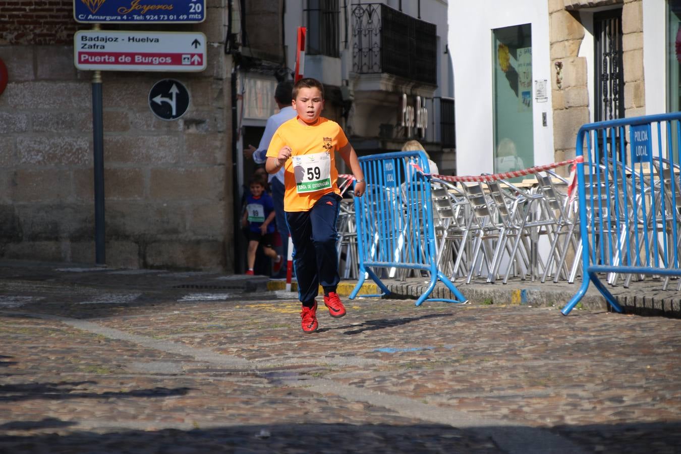 La Plaza de España de Jerez de los Caballeros acogió, ayer, la XXI Carrera Popular y VIII Caminata por la Salud y Solidaridad, organizada por la Concejalía de Juventud y Deportes del Ayuntamiento de Jerez con el apoyo del Programa de Dinamización Deportiva de la Mancomunidad Sierra Suroeste. Esta edición congregó a más de 250 participantes entre todas las categorías y se recaudaron 84 kilos de alimentos y 75 euros destinados a Cruz Roja en Jerez. La citada prueba se consagra, año tras año, como una de las citas deportivas ineludibles y más esperadas por los jerezanos y jerezanas. 