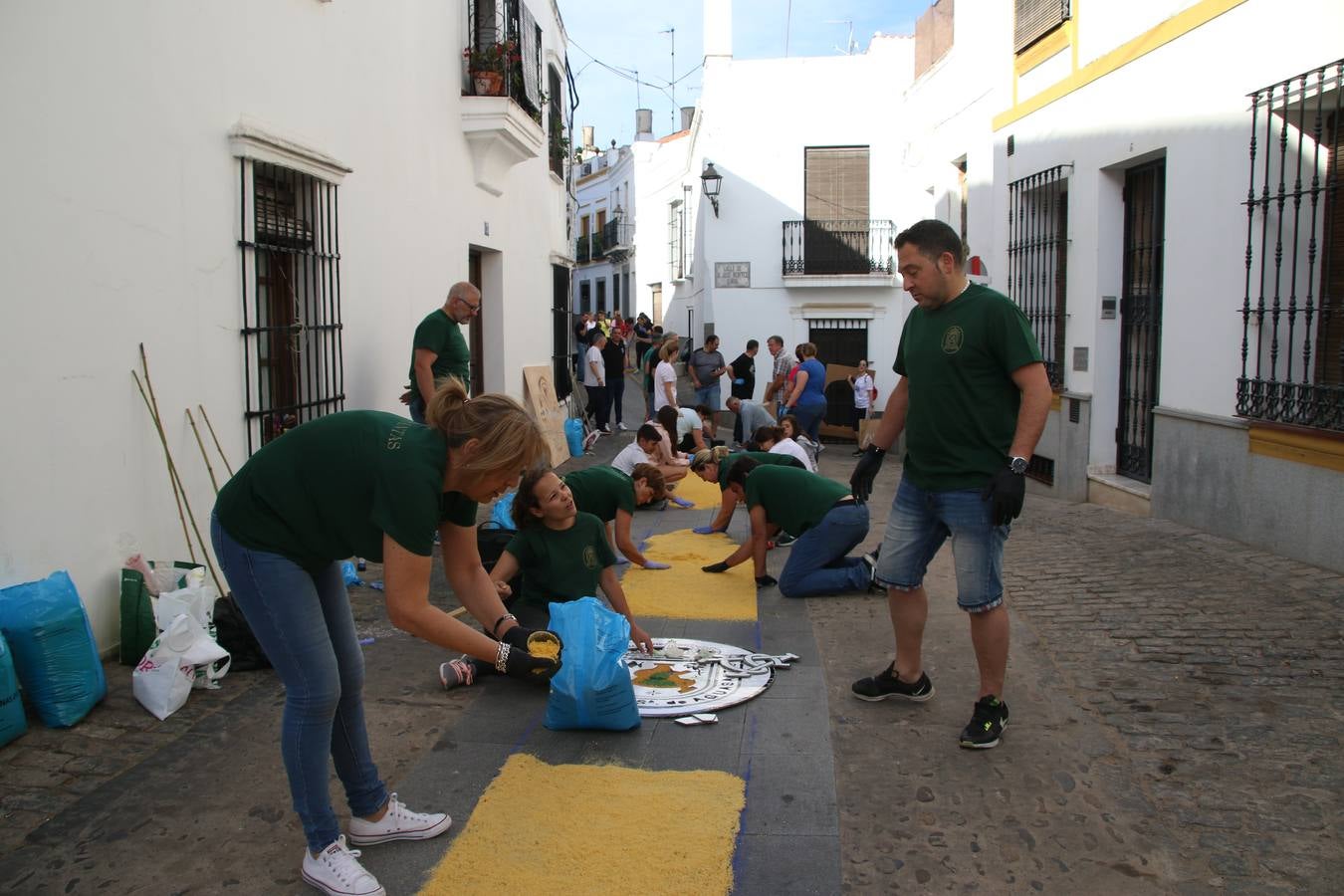Las alfombras de sal embellecen y llenan de color, hoy, las calles de Jerez de los Caballeros con motivo de la festividad del Corpus Christi. Desde primera hora de la mañana, miembros de las cofradías y hermandades, Cáritas, grupos de catequesis, familias de los niños que han hecho este año la Primera Comunión, miembros de la Asociación de costaleros y costaleras de la Semana Santa jerezana, Ayuntamiento y vecinos han cubierto las principales calles del municipio con 6.250 kilos de sal teñida, plenas de color. A continuación, han disfrutado de una jornada de convivencia en la Casa de la Iglesia 'Cecilia de Arteaga'.