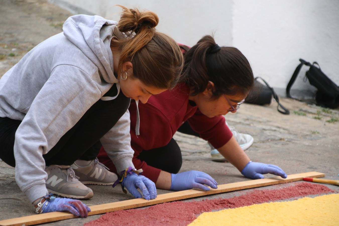 Las alfombras de sal embellecen y llenan de color, hoy, las calles de Jerez de los Caballeros con motivo de la festividad del Corpus Christi. Desde primera hora de la mañana, miembros de las cofradías y hermandades, Cáritas, grupos de catequesis, familias de los niños que han hecho este año la Primera Comunión, miembros de la Asociación de costaleros y costaleras de la Semana Santa jerezana, Ayuntamiento y vecinos han cubierto las principales calles del municipio con 6.250 kilos de sal teñida, plenas de color. A continuación, han disfrutado de una jornada de convivencia en la Casa de la Iglesia 'Cecilia de Arteaga'.