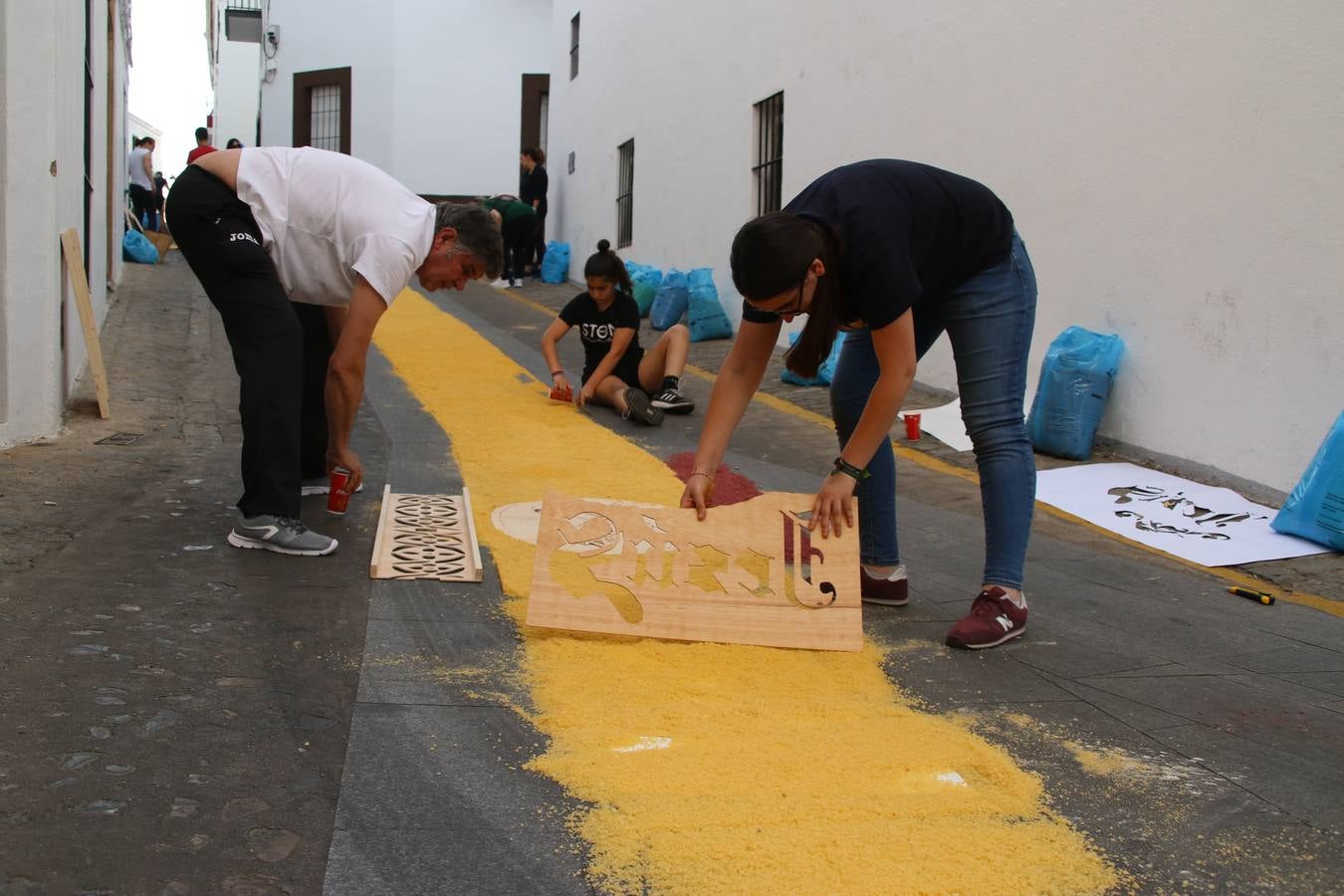 Las alfombras de sal embellecen y llenan de color, hoy, las calles de Jerez de los Caballeros con motivo de la festividad del Corpus Christi. Desde primera hora de la mañana, miembros de las cofradías y hermandades, Cáritas, grupos de catequesis, familias de los niños que han hecho este año la Primera Comunión, miembros de la Asociación de costaleros y costaleras de la Semana Santa jerezana, Ayuntamiento y vecinos han cubierto las principales calles del municipio con 6.250 kilos de sal teñida, plenas de color. A continuación, han disfrutado de una jornada de convivencia en la Casa de la Iglesia 'Cecilia de Arteaga'.