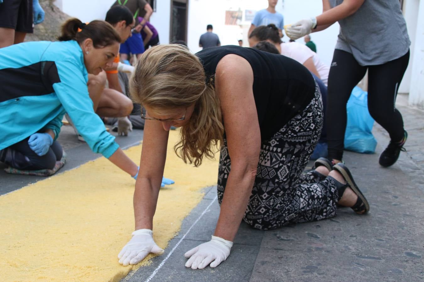Las alfombras de sal embellecen y llenan de color, hoy, las calles de Jerez de los Caballeros con motivo de la festividad del Corpus Christi. Desde primera hora de la mañana, miembros de las cofradías y hermandades, Cáritas, grupos de catequesis, familias de los niños que han hecho este año la Primera Comunión, miembros de la Asociación de costaleros y costaleras de la Semana Santa jerezana, Ayuntamiento y vecinos han cubierto las principales calles del municipio con 6.250 kilos de sal teñida, plenas de color. A continuación, han disfrutado de una jornada de convivencia en la Casa de la Iglesia 'Cecilia de Arteaga'.
