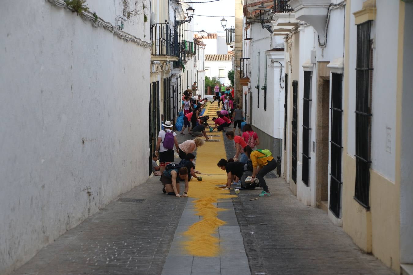 Las alfombras de sal embellecen y llenan de color, hoy, las calles de Jerez de los Caballeros con motivo de la festividad del Corpus Christi. Desde primera hora de la mañana, miembros de las cofradías y hermandades, Cáritas, grupos de catequesis, familias de los niños que han hecho este año la Primera Comunión, miembros de la Asociación de costaleros y costaleras de la Semana Santa jerezana, Ayuntamiento y vecinos han cubierto las principales calles del municipio con 6.250 kilos de sal teñida, plenas de color. A continuación, han disfrutado de una jornada de convivencia en la Casa de la Iglesia 'Cecilia de Arteaga'.